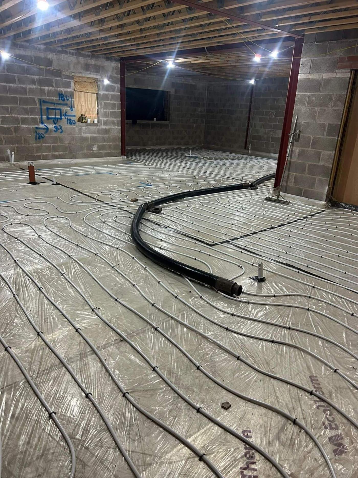 Liquid screed being pumped over underfloor heating